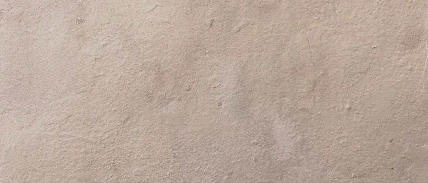 Texture d'un enduit mural beige légèrement nuancé