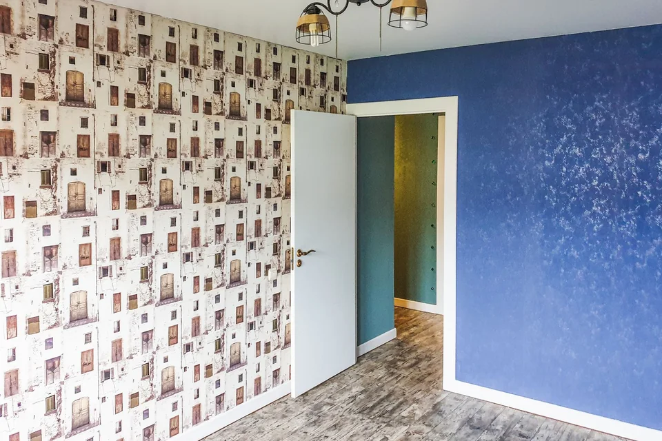 Pièce associant un papier peint à motifs et un mur peint en bleu